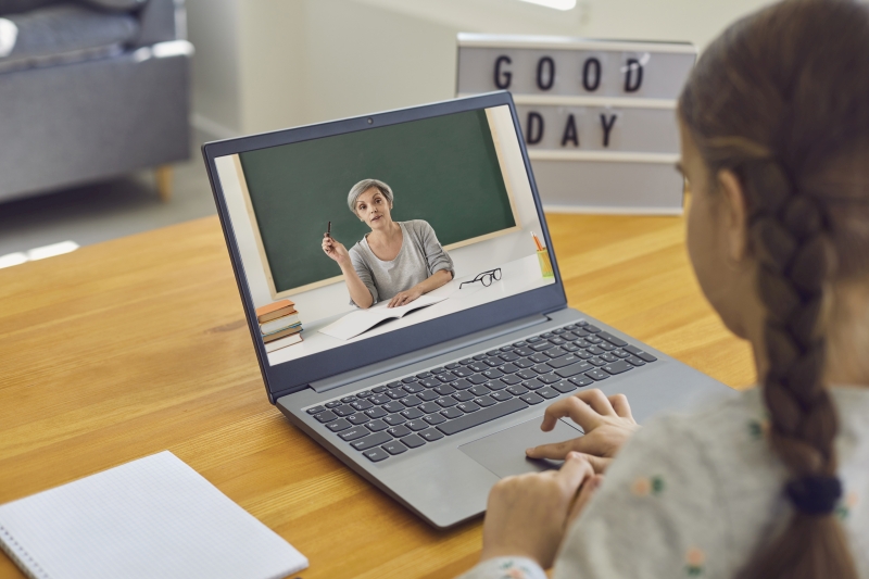 Schülerin an Laptop mit Lehrerin im Distanzunterricht