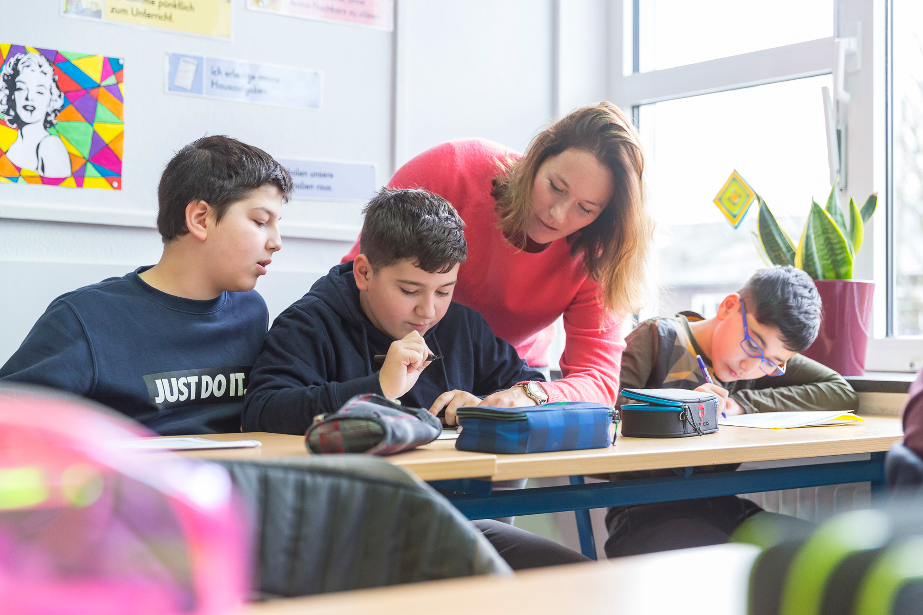 Lehrerin erklärt etwas einem Schüler