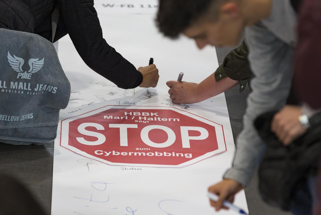 Jugendliche malen ein Bild gegen Cybermobbing