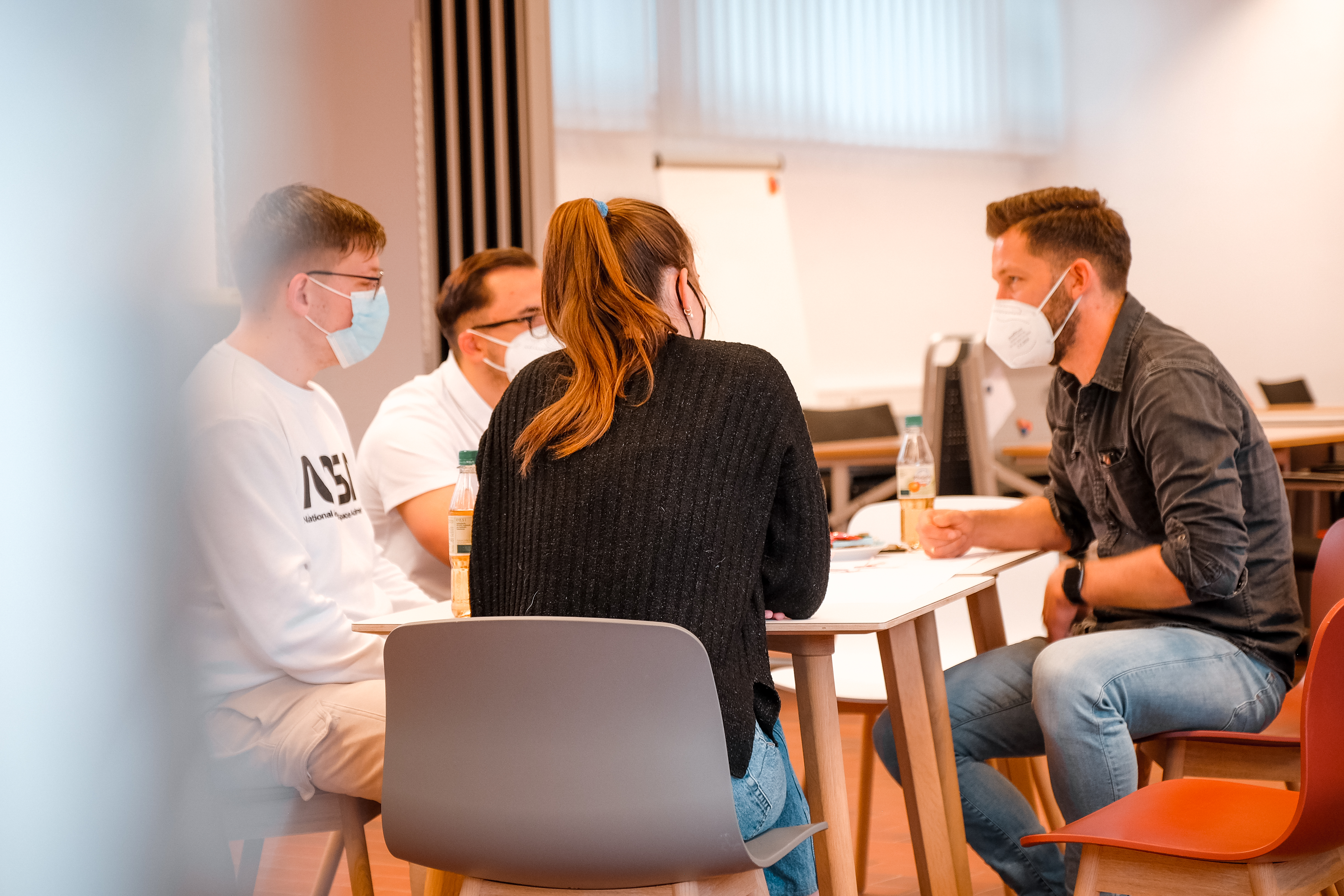 mehrere Personen sitzen an einem Tisch
