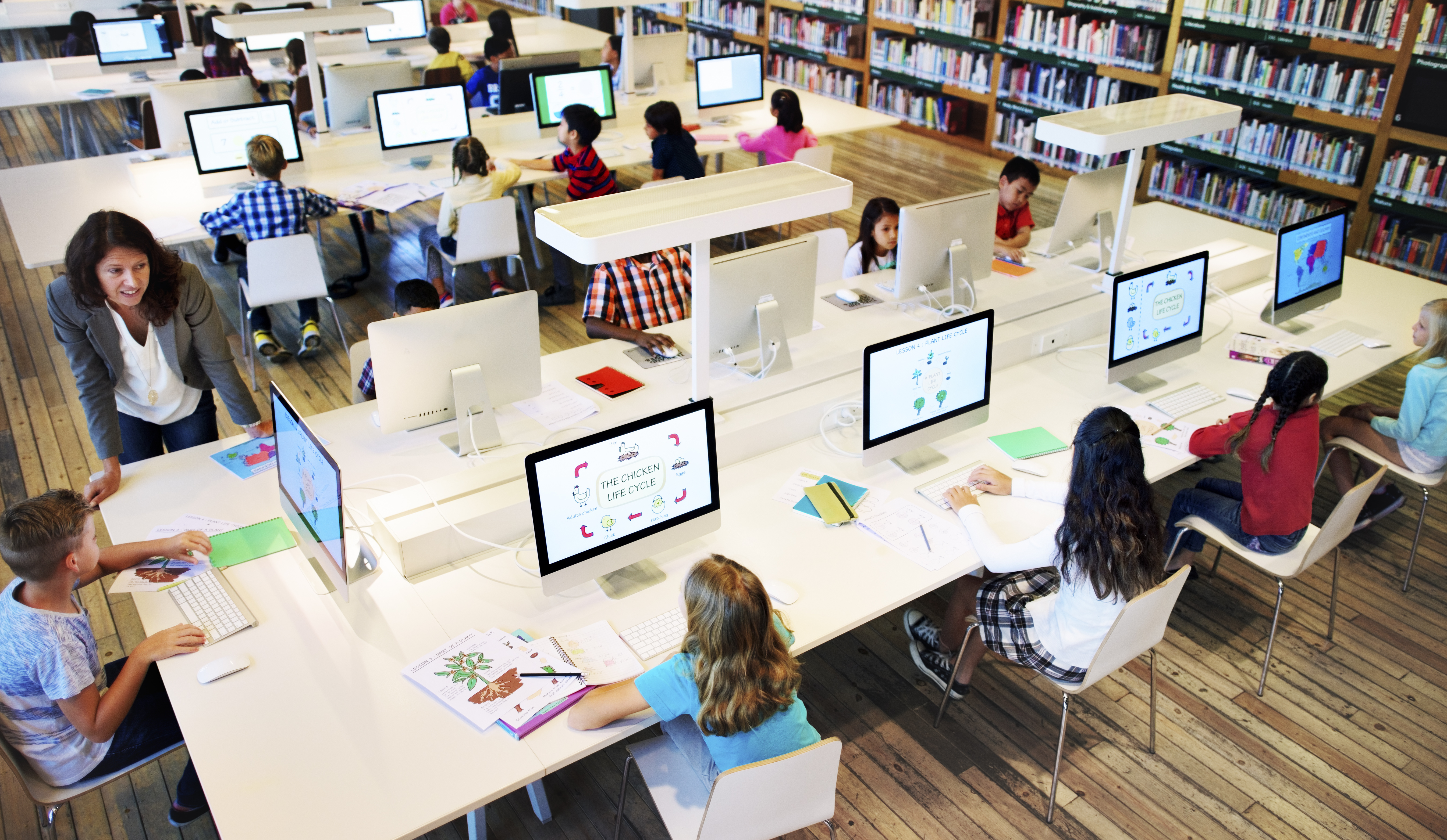 Kinder und Lehrerin an Computern