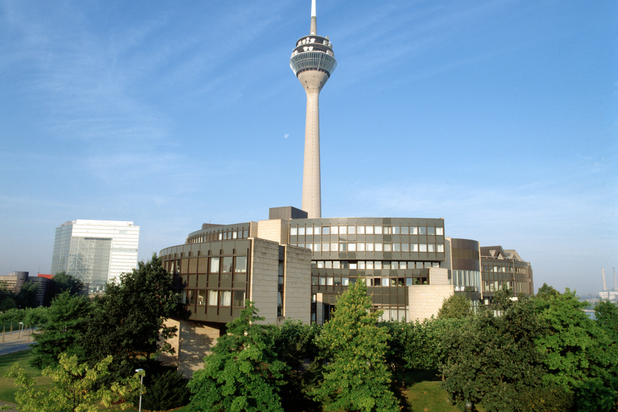 Der Landtag Nordrhein-Westfalen bei Sonnenlicht mit Fernsehturm im Hintergrund