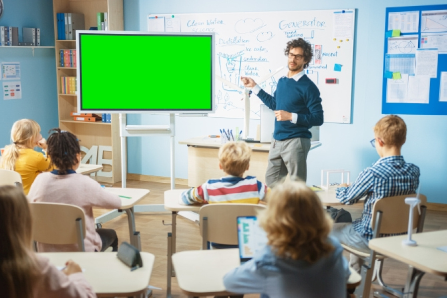 Lehrer mit grünem Bildschirm vor Klasse