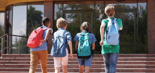 Vier Schulkinder mit Rucksäcken