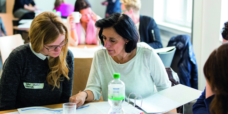 Zwei Lehrerinnen arbeiten gemeinsam an Schreibtisch