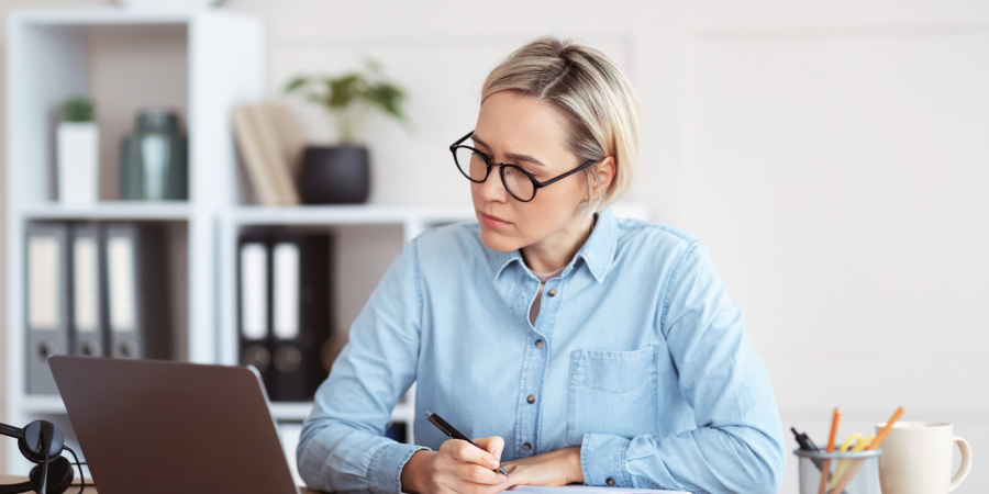 Am Laptop sitzende Frau, die sich Notuzen macht