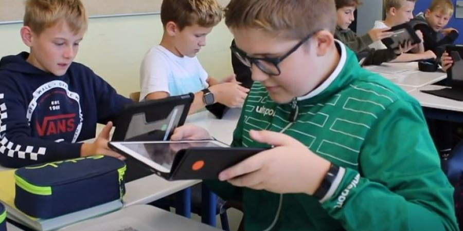 Film Klasse!Digital Mehrere Jungen mit iPad in der Hand in der Schule