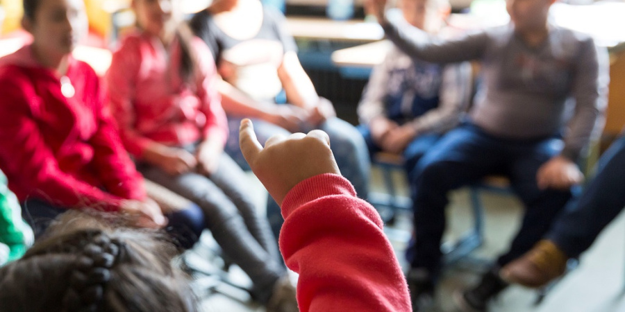 Aufzeigenes Kind im Stuhlkreis