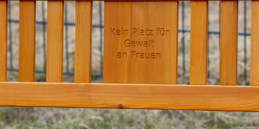Detailansicht der orangefarbenen Bank mit RuhrFutur-Logo und Aufschrift "Kein Platz für Gewalt an Frauen"