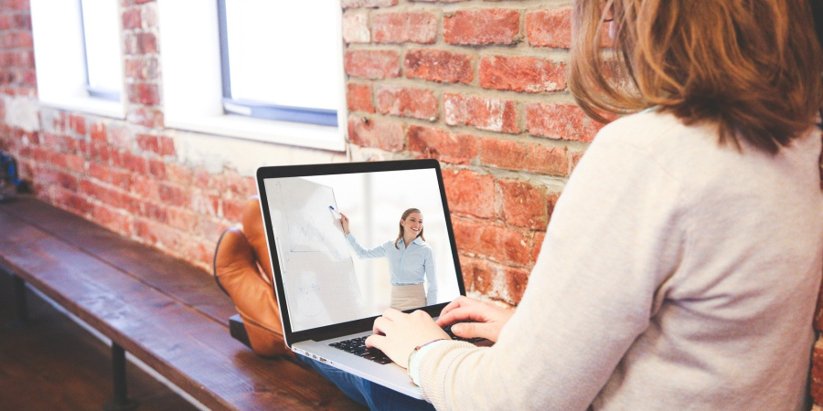 Frau mit Laptop auf dem Schoß