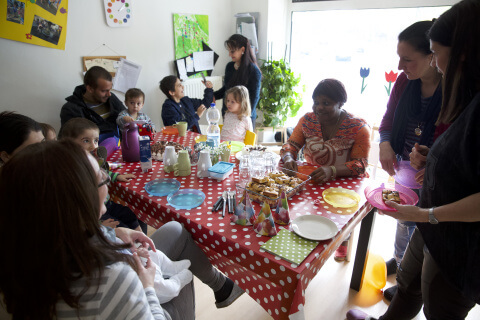 Kinder, Eltern und Mitarbeiter*innen beim Essen