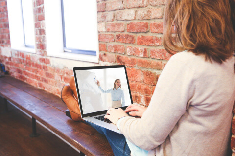 Frau mit Laptop auf dem Schoß